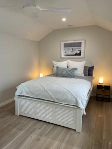 a bedroom with a white bed with two lamps on it at Bryon's secret hideout studio in Byron Bay
