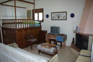 a living room with a couch and a tv at Manos House in Monólithos