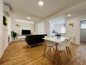 a dining room and living room with a table and chairs at Gaude - Apartamento de diseño con Patio - in Albacete