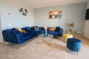 un salon avec un canapé bleu et une table dans l'établissement Blu paradise,a ray of sunshine between sea & pool, à Agadir