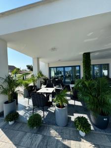 a patio with tables and chairs and potted plants at Pensiunea Paradisul Mării in Sulina