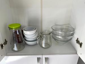 a white cabinet with glass bowls and jars at Apartamento no centro girassol 05 in Foz do Iguaçu