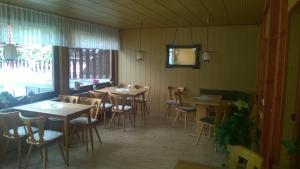 Wiedaer Hütte في Wieda: غرفة طعام بها طاولات وكراسي ونافذة
