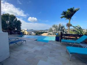 uma piscina com um banco e palmeiras em Deluxe Modern 1BR I Pool with Amazing Sea Views I Ideal Location em Gros Islet