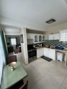 uma cozinha com armários brancos e uma mesa verde num quarto em Deluxe Modern 1BR I Pool with Amazing Sea Views I Ideal Location em Gros Islet