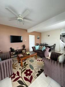 uma sala de estar com 2 sofás e uma televisão de ecrã plano em Deluxe Modern 1BR I Pool with Amazing Sea Views I Ideal Location em Gros Islet mais 6 fotografias