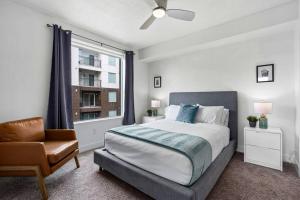 a bedroom with a bed and a chair and a window at Gorgeous Central City 2BD 2BA in Salt Lake City