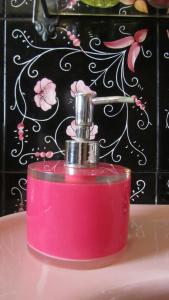 a pink bottle of soap sitting on a sink at Bed & Breakfast Alice in Valderice