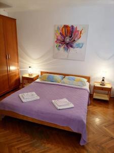 a bedroom with a bed with two towels on it at Apartments with a parking space Losinj, Losinj - 23520 in Mali Lošinj