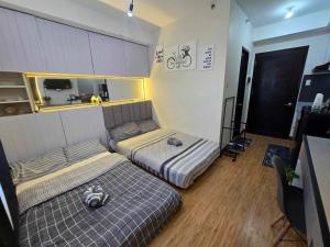 a bedroom with two beds in a room at roberts loft 12mT3 mesaverte near SM and Ayala in Pontud