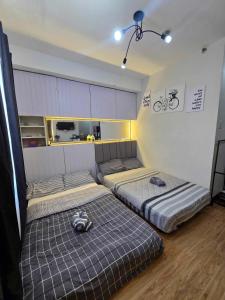 a room with two beds in a room at roberts loft 12mT3 mesaverte near SM and Ayala in Pontud +38 photos