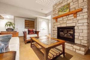 卡尔加里Escape to the Rockies but near Calgary Includes Free Parking and Banff Entry的客厅设有石制壁炉和桌子。