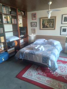 a bedroom with a bed and a book shelf at QUINTAS DA BARRA BNB a 30m da praia in Balneario Barra do Sul