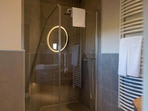a bathroom with a shower with a sink and a mirror at Nature Retreat with Pools in Antoing +32 photos