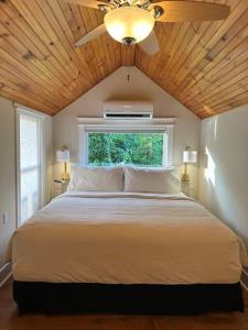 a bedroom with a large white bed with a ceiling fan at Lovely private home in a serene neighborhood in Totowa