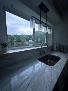 a kitchen with a sink and a large window at Lovely private home in a serene neighborhood in Totowa