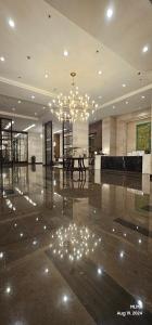 a lobby with a chandelier and a table in it at Serenity by Zen Residences at The Radiance Manila Bay in Manila +54 photos
