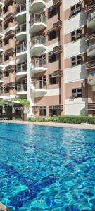 a swimming pool in front of a building at Serenity by Zen Residences at The Radiance Manila Bay in Manila