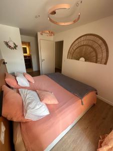 a bed in a room with two pillows on it at Appartement ROSE, Aéroport ST EXUPERY, Groupama stadium, Eurexpo, LDLC Arena in Pusignan