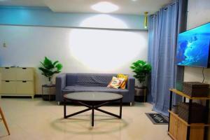 a living room with a couch and a table at The Loft Nook - 2 bedrooms only in Pusok