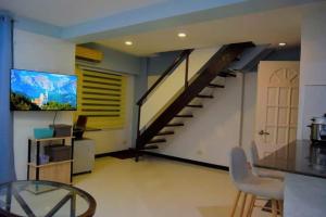 a living room with a staircase and a table and chairs at The Loft Nook - 2 bedrooms only in Pusok