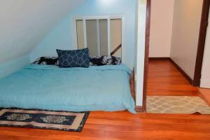 a bedroom with a blue bed with pillows on it at The Loft Nook - 2 bedrooms only in Pusok