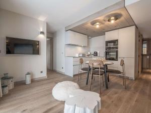 una cucina e una sala da pranzo con tavolo e sedie di Charmant appart à Courchevel Village, proche pistes, 2 ch, SPA & WIFI - FR-1-631-210 a Courchevel