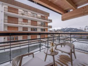 un balcone di un edificio con tavolo e sedie di Charmant appart à Courchevel Village, proche pistes, 2 ch, SPA & WIFI - FR-1-631-210 a Courchevel