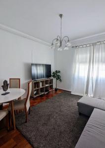 a living room with a couch and a table and a tv at Centro Cidade Holiday in Portimão +13 photos