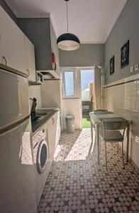 a kitchen with a table and a washing machine at Centro Cidade Holiday in Portimão