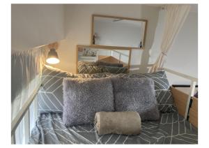 a room with a bed with pillows and a mirror at Bohemian Inspired Studio Unit1 at Trees Residences in Manila