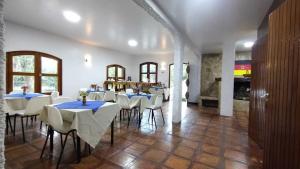 a dining room with white tables and white chairs at Suíte Família vizinha do Palácio de Cristal em Petrópolis! in Petrópolis