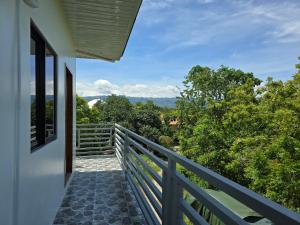 a balcony with a view of the forest at Mollucan Suite Moalboal in Moalboal