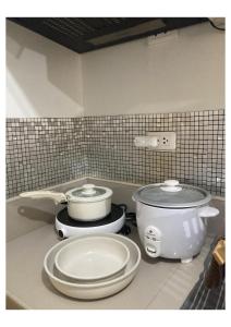 a kitchen counter with two pans and a crock pot at Bohemian Inspired Studio Unit1 at Trees Residences in Manila