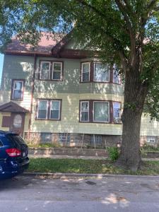a green house with a tree in front of it at Apartamento en Milwaukee cerca del centro 8 mins from Milwaukee downtown in Milwaukee