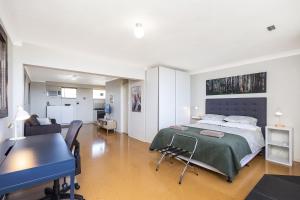 a bedroom with a bed and a dining room at Ocean Breezes in Fremantle