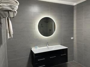 a bathroom with a sink and a mirror at Golden Chain Country Plaza Motel Halls Gap in Halls Gap +51 photos