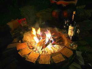 a fire pit with some food and a bottle of wine at Montelungo Cabañas Glamping in Chimbe