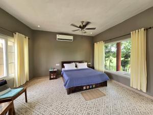 a bedroom with a bed and a ceiling fan at Rustic Roots Farm Stay in Atāri