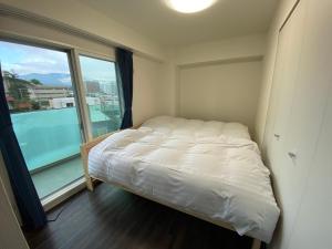 Llit o llits en una habitació de ホテル小樽キャナルビュー AMS東雲