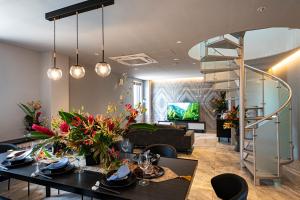 a living room with a table and a spiral staircase at Angelroad Hotel in Tonosho