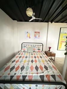ein Schlafzimmer mit einem Bett, auf dem eine Steppdecke liegt in der Unterkunft Mountain View Cabin 1 in Tanay + 8 Fotos