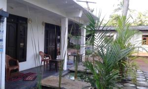 un porche de una casa con una mesa y una silla en Riverside Lal Homestay, en Sigiriya