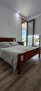 ein Schlafzimmer mit einem großen Bett mit einem großen Fenster in der Unterkunft Casa Quinta Búho Norte in Resistencia