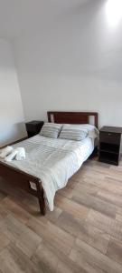 ein Bett in einem Schlafzimmer mit Holzboden in der Unterkunft Casa Quinta Búho Norte in Resistencia + 8 Fotos