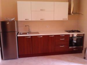 una cucina con mobili in legno e un frigorifero in acciaio inossidabile di Große Wohnung in Gabonjin mit Eigener Terrasse a Gabonjin