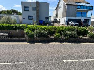 a house and a car parked in front of a street at Sennen Cove Cottage in Sennen Cove