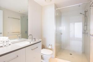 a white bathroom with a shower and a toilet at Circle on Cavill 2, 3, 4 & 5 Bedroom SkyHomes & SUB PENTHOUSES by Gold Coast Holidays in Gold Coast