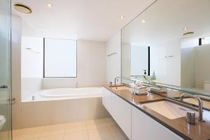 a white bathroom with a tub and a sink at Circle on Cavill 2, 3, 4 & 5 Bedroom SkyHomes & SUB PENTHOUSES by Gold Coast Holidays in Gold Coast