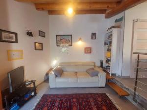 un soggiorno con un divano bianco e una TV di Studio terrasse climatisé VUE MER avec parking a Cardo